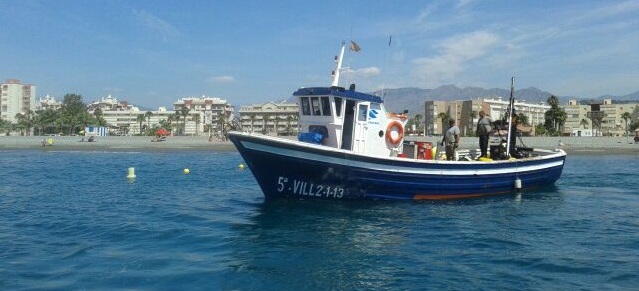 Barco balizando una de las playas de la Costa Tropical