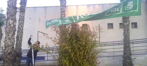 Un militante socialista retira una pancarta del PSOE tras las elecciones autonómicas