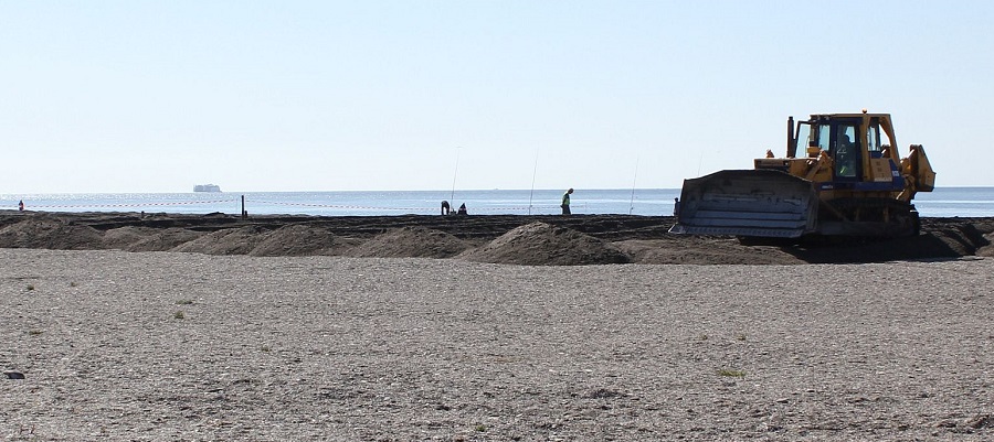 Máquina retroexcavadora trabajando en la adecuación de la Playa de Poniente_