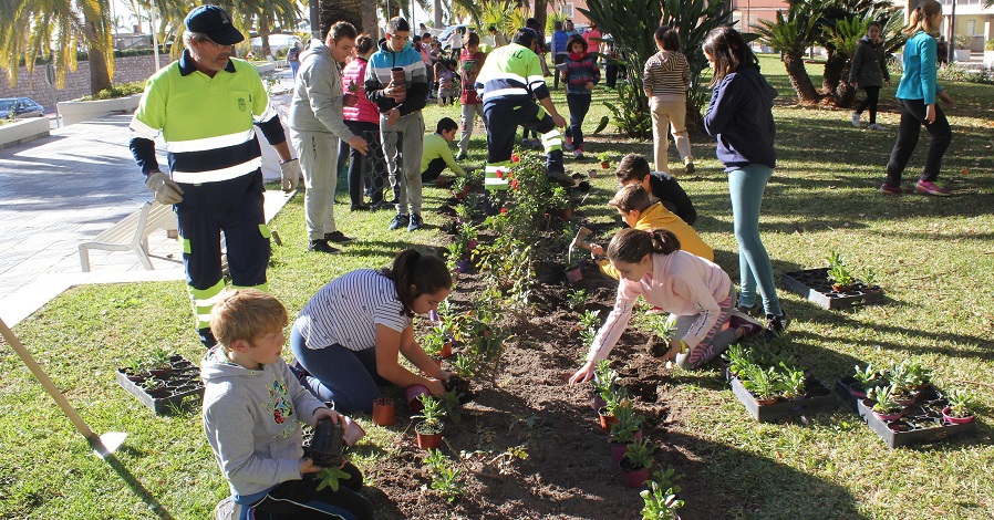 Alumnos de los colegios Reina Fabiola y Luis Pastor plantan flores en los jardines del paseo de las Explanadas