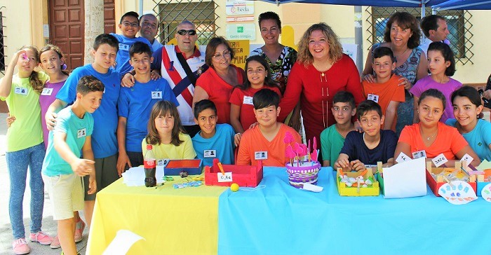 Foto archivo Flor Almón y Mercedes Sánchez junto a los niños y niñas del CEIP Arco Iris en la I Feria del Emprendimiento